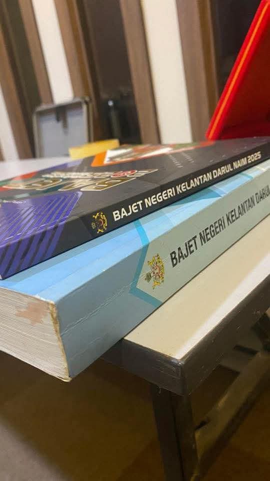 "Kita lihat hari ini RMK13 nipis berbanding RMK12 yg setebal ini. Kenapa berlaku perbezaan antara dua RMK ini sedangkan kita berapa di negara yg sama." - MP Tumpat

Sementara itu Buku Bajet Negeri Kelantan 2025 vs tahun sebelumnya.