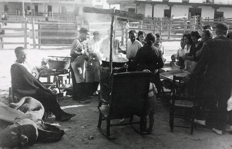 📷 Un grupo de gente espera su vez para comprar churros en la plaza durante las fiestas de Valdemoro, 1950. Foto: Pedro Rincón. Colección “Madrileños” (Archivo del Ayuntamiento de Valdemoro. Fotografía cedida por Maruja Rincón), ARCM.