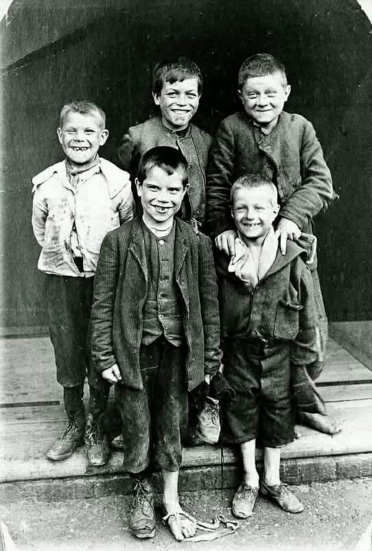 In 1902, a group of children from Plaistow, East London, stood together for a photograph—ragged, barefoot, and full of mischief. Their faces, marked by both hardship and youthful defiance, tell a story of resilience in a time when poverty was a daily battle. Yet, despite their