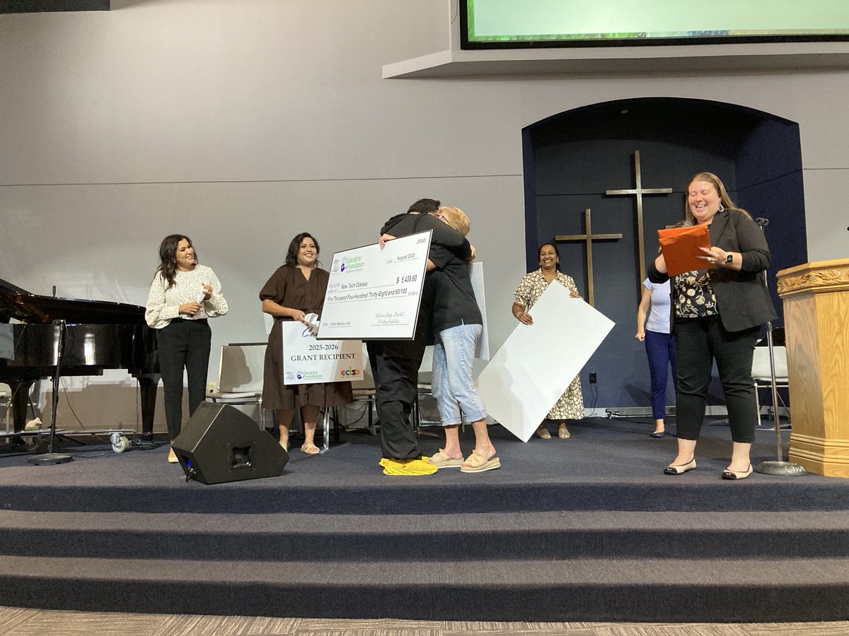 New tech art teacher Jose Valeriano hugs Ecisd board of trustees president Tammy Hawkins after being surprised with an education foundation grant Tuesday.