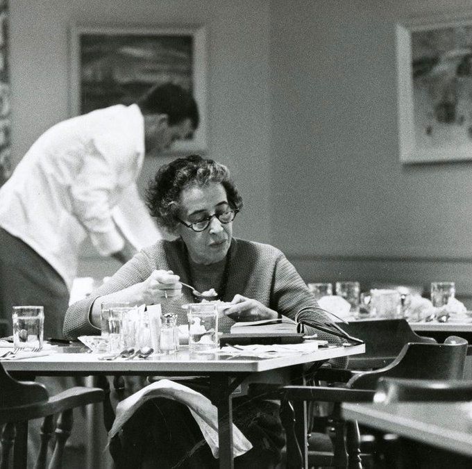 Hannah Arendt comiendo el postre y leyendo, indiferente a la sutil invitación del camarero a retirarse del comedor