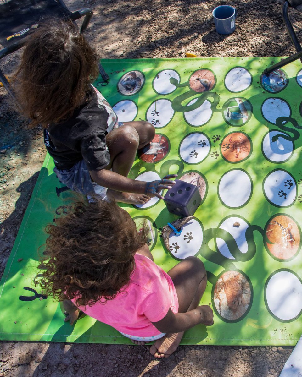 KJMartu's tweet photo. At Jila-Jila, #MartuFamilies from the #KJWomensAndFamiliesProgram in #Punmu spent the day #OnCountry. The kids explored Country then played Martu Snakes + Ladders, created by the #KJLanguage Team, to learn animals from #MartuCountry in #MartuWangka. #KeepingCultureStrong https://t.co/OSbRuYHl1f