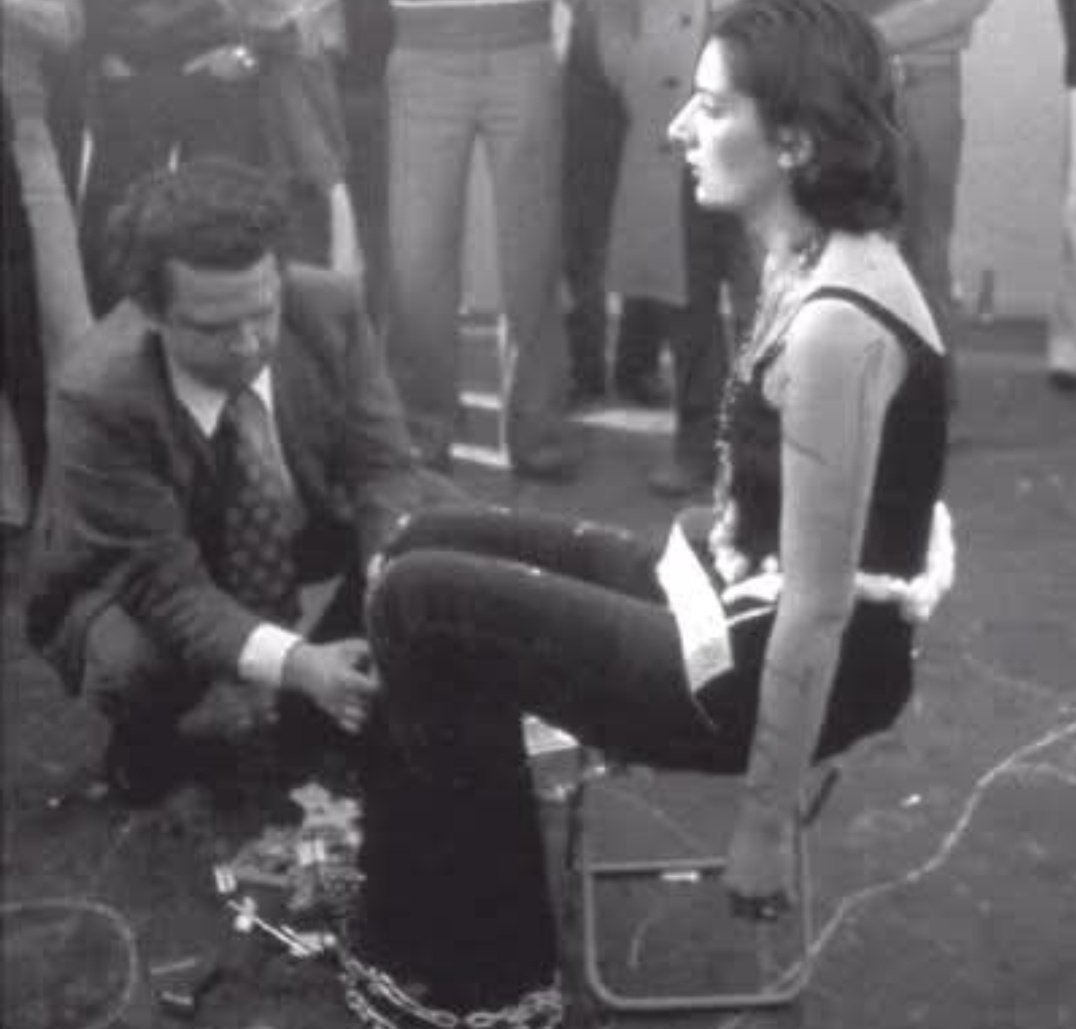 Frenkie_Woody's tweet photo. Nel 1974, Marina Abramović intraprese un esperimento sociale rivoluzionario che sfidava i limiti del comportamento umano. Dispose un tavolo con 72 oggetti, che spaziavano da elementi innocui come fiori a armi pericolose, compresa una pistola carica, e si dichiarò completamente passiva per sei ore. Il suo invito era semplice ma profondo: le persone potevano fare qualsiasi cosa volessero, e lei non avrebbe reagito.

All’inizio, i visitatori si avvicinarono con gentilezza—offrendo fiori, sorrisi e tocchi delicati. Ma con il passare delle ore, l’atmosfera cambiò drasticamente.

L’esperimento rivelò presto un lato più oscuro della natura umana. Gli atti di aggressione e irrispetto aumentarono: alcuni partecipanti cominciarono a tagliarle i vestiti, graffiarle la pelle, premere spuntoni sul corpo e persino maneggiare la pistola, con una persona che mise il dito sul grilletto. Nonostante ciò, nessuno intervenne per proteggerla o difenderla, mostrando quanto facilmente empatia e limiti sociali possano crollare quando sparisce la responsabilità. L’assenza di reazione di Marina sembrava incoraggiare le persone a superare limiti che probabilmente non avrebbero mai oltrepassato in circostanze normali.

Quando le sei ore terminarono e Marina finalmente si mosse, la folla si disperse rapidamente, molti incapaci di incontrare il suo sguardo—forse confrontati con le proprie azioni. Questo esperimento fu più di una performance artistica; fu un riflesso crudo sulla psicologia umana, mostrando come dinamiche di potere e disumanizzazione possano liberare crudeltà quando spariscono i vincoli morali. Ci costringe a chiederci: fino a che punto arriveremmo se non ci fossero conseguenze?

Il lavoro di Marina resta uno specchio potente sulla fragilità della civiltà e sulla profondità del comportamento umano.