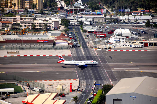 gotravelyourway's tweet photo. This runway has something unusual.. a busy public road crosses right through it. Where in the world is this? https://t.co/83jH9lOqNt