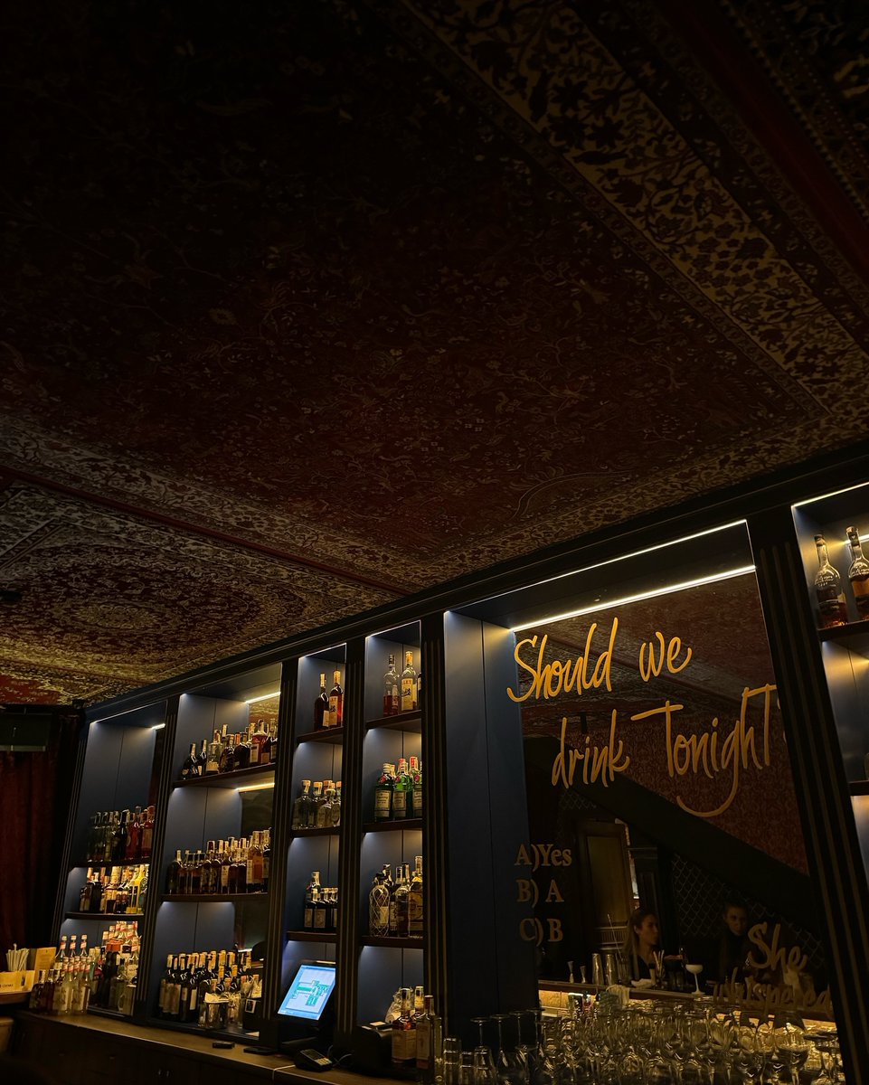 Angelina_891027's tweet image. ✨ Ceiling draped like a Persian dream, shelves glowing with choices. That golden question hanging — the answer’s always yes. 🍸✨
#VintageBar #MoodyElegance #DrinkTonight