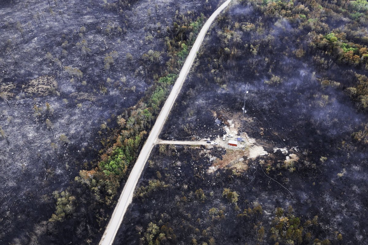 Communications tower protected by structure protection measures and a dozer guard, surrounded by burnt forest. (Province of Nova Scotia)