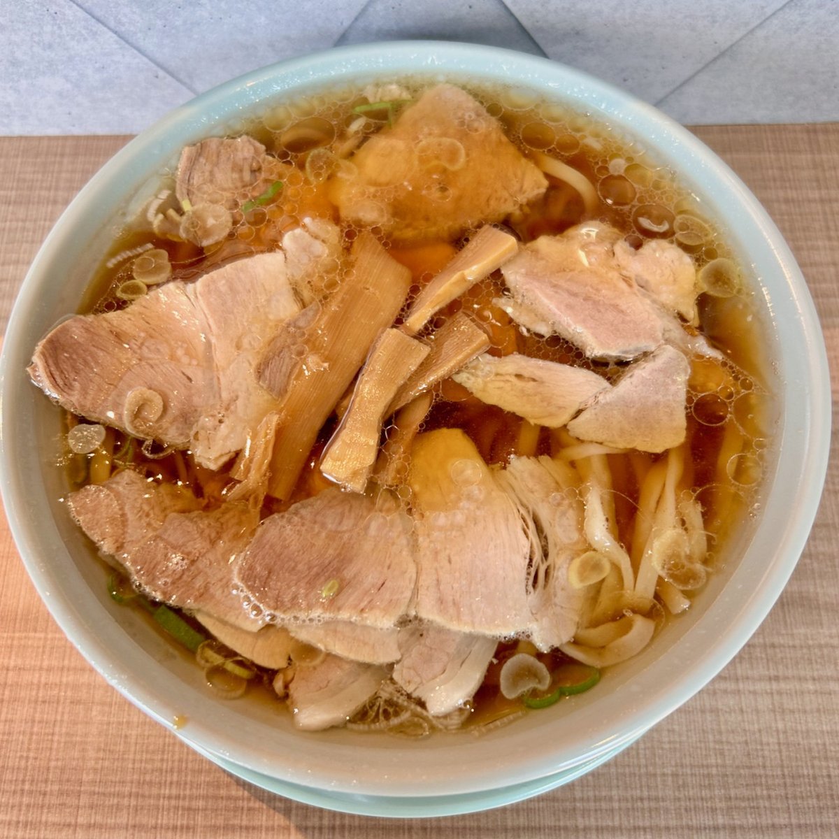 supleks_jp's tweet photo. 8/22(金)　本日の一杯🍜✨
富喜製麺研究所 五反田店（東京都品川区五反田駅）
【開店記念】チャーシュー麺：650円
https://t.co/UaQscIpa6J

2025年8月20日オープン。熊本の製麺所発祥のラーメン・つけ麺店。熊本が益城本店・熊本駅店・熊本つけそばFUUKI・菊陽店・サクラマチ店・熊本駕町店の6店舗。京都1店舗、大阪2店舗、東京が六本木店、三軒茶屋店に続き、3店舗目。本店が一番古く、それでも2021年7月と、いずれも最近なのでスゴい連続展開。

昨日は開店半額サービスをやっていたとのことでスゴい行列が出来ていたことは知っていた。今日もやっているのだったら、明日以降にするつもりだったが、公式サイト・公式Facebook・公式Instagram、どれもチェックしたら書いてなかったので、外出の帰り道（要するに2軒目）に寄ってみたら、まだ半額サービス中。12時45分着で約20人待ち。私の方針としてラーメン店さんにはちゃんとお支払いしたいので呼ばれた試食会以外では普通に支払って食べたいのだが、この日は他に行く時間も無かったので並んでしまった。そしたら有名ラーメン店社長が通りかかり「大崎さんも行列に並ぶんですね。しかも半額セールに！」いやまあ、その、いろいろありまして・・・。

主なメニュー、鰹昆布水のどごし生つけそば（温or冷）500円、ちゃん系中華そば500円、ちゃん系チャーシュー麺650円、つけそばタレ2種550円、ぶっかけのどごし生麺420円、他。一応、半額表示らしいが通常時にこの単純倍になるのかどうかは未確認。（三軒茶屋店では鰹昆布水のどごし生つけそばが1300円、中華そばが1200円）

ワンコインだと申し訳なくてチャーシュー麺650円にしたが、お店にとってはどちらがいいのだろうか？
店内は、立ち食い8人ほどが立てる。入口は一つだが奥に出口専用もあり、そちらから出る人が多い。入口は段差が大きく、足腰の弱い人だと帰りがチョット大変かも。全体重が片足にかかる。ちょっと危険な段差。奥から出るのが無難。

出てきた「ちゃん系中華そば」はパッと見、よく似ている。そういや、「ちゃん系」は商標を取っているが大丈夫なんだろうか？「ちゃん系らーめん」「ちゃん系中華そば」は株式会社凪スピリッツジャパンが取っている。参考までに「横浜家系ラーメン」はこれだけだと取れないのか、多くは店名含みで取っている。例「横浜家系ラーメン町田商店」「横浜家系ラーメン　魂心家」など。

スープは豚骨清湯だと思うが、ちゃん系よりも優しい印象。ちゃん系を食べると「なんでこんなにしょっぱくて油が多いんだろう？？」と怒りたくなるが、それがクセになり、はまるのだ。しかし、こちらは随分優しい。朝6時までの営業なので軽めの味にしているのか？しょっぱさまではインスパイアしていない。また、チャーシューだが、こちらもそんなに味は濃くなく、ちゃん系のように柔らかく煮込んで醤油タレに漬け込んで置くタイプではない。ちゃん系を食べるとそのチャーシューのしょっぱさに怒りたくなるのだが（笑）、こうして普通のタイプを食べるとなんだか改めてあのしょっぱいのを食べたくなるから不思議だ（笑）。麺はピロピロ平打ちのかなり柔らかめ。当然ながら自家製だろう。

いよいよ「ちゃん系」を名乗るところが出てきて（かつて他にもメニュー名に付けていたところがあったがそこはすぐに変更した。）「ちゃん系」も“ラーメン用語”として定着しそうだ。それにしても“ちゃん系インスパイア”を何軒か食べてみたが、食べるたびに改めてあのラーメンはよくできている、と感心する。

近いし、駅前だし、平日は朝6時までやっているので、機会があればつけ麺も食べに来てみようと思う。
※開店記念の半額セールは20日21日のみ。