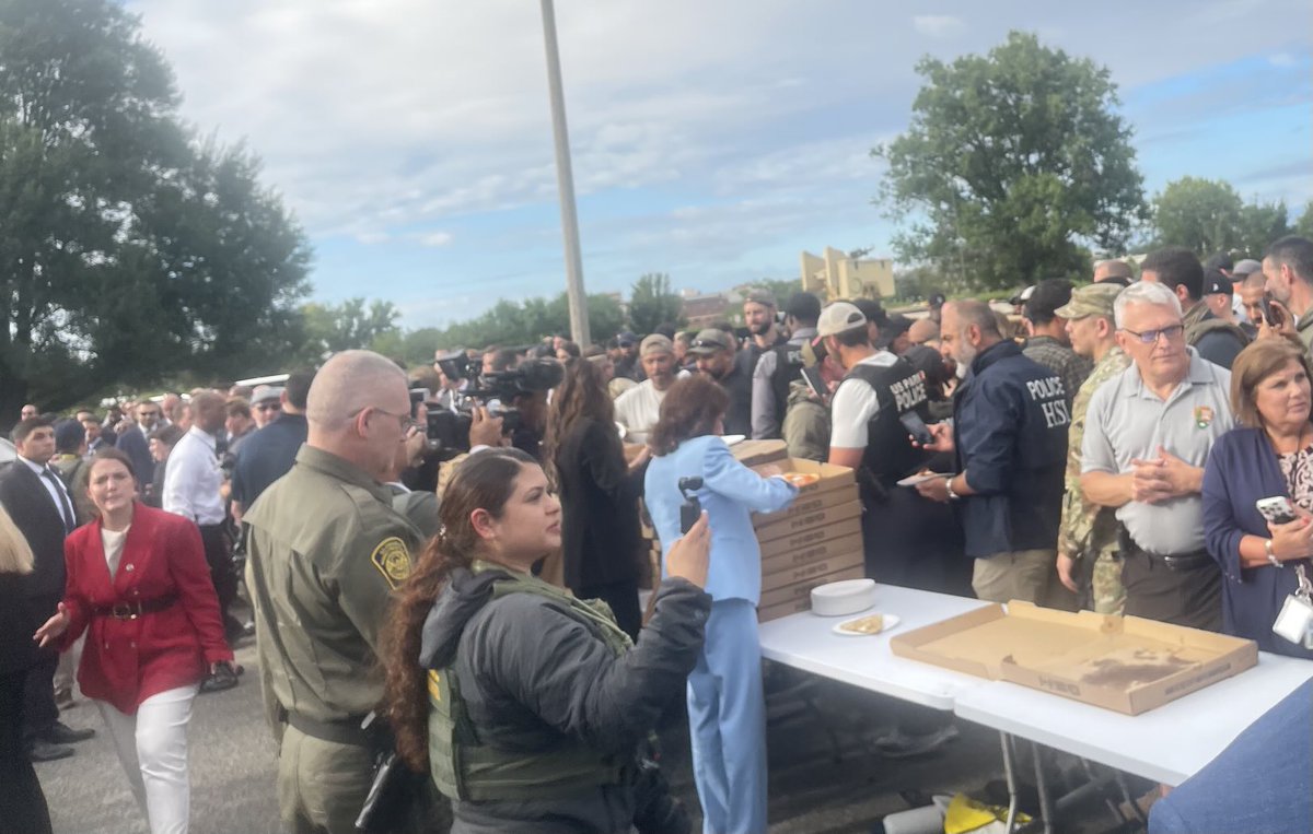 Noem and Pirro hand out pizza to the group of officers