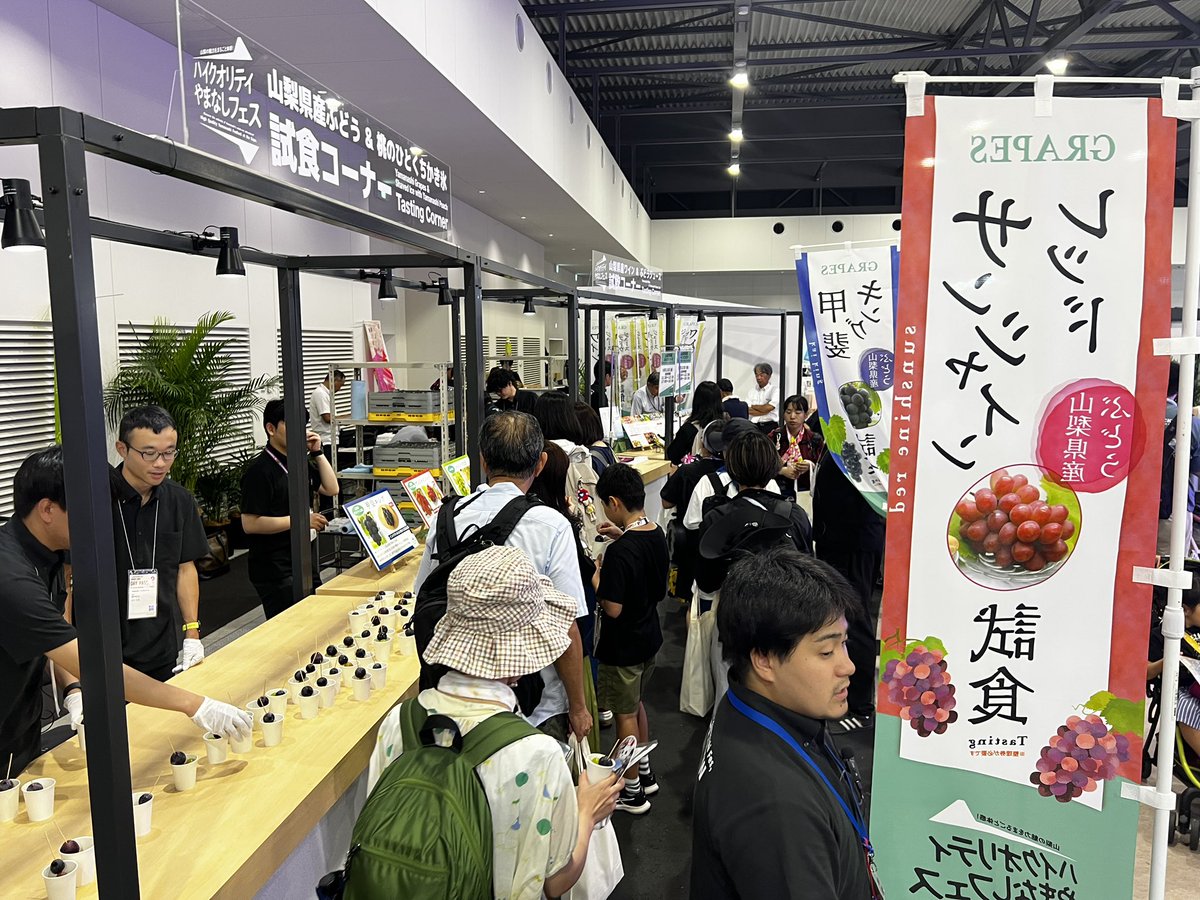 sannichi's tweet image. 【大阪・関西万博 現地レポート④】
万博の山梨県ブースでは、県産ブドウやワイン、コメ、お茶、かき氷などが振る舞われ、整理券を求める来場者が行列をつくりました。