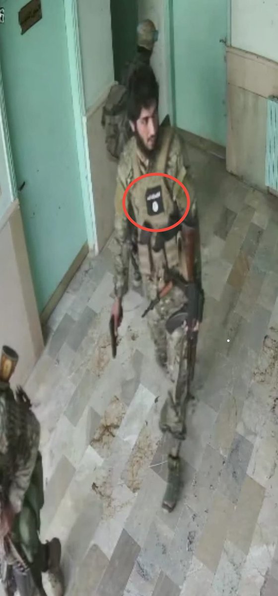 Bu fotoğraf kaydı, Suriye Geçici Hükümeti Savunma Bakanlığı’na bağlı güçlerin Süveyda kentindeki El-Watenî Hastanesi’nde gerçekleştirdiği katliam anlarına ait güvenlik kamerası görüntülerinden alındı.

Görüntülerde, Savunma Bakanlığı’na bağlı bir personelin üniformasında DAİŞ