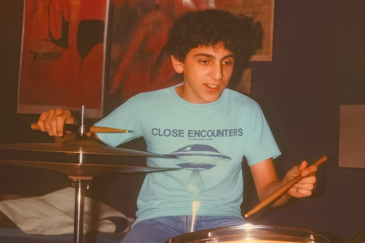 Here's me with that Close Encounters t-shirt as I played my drums in 1977 or 1978. And...the ChatGPT cleaned-up version, which makes me look a lot older.

Behind me is Farrah, "Chrissy Snow" and I believe, Cheryl Tiegs.