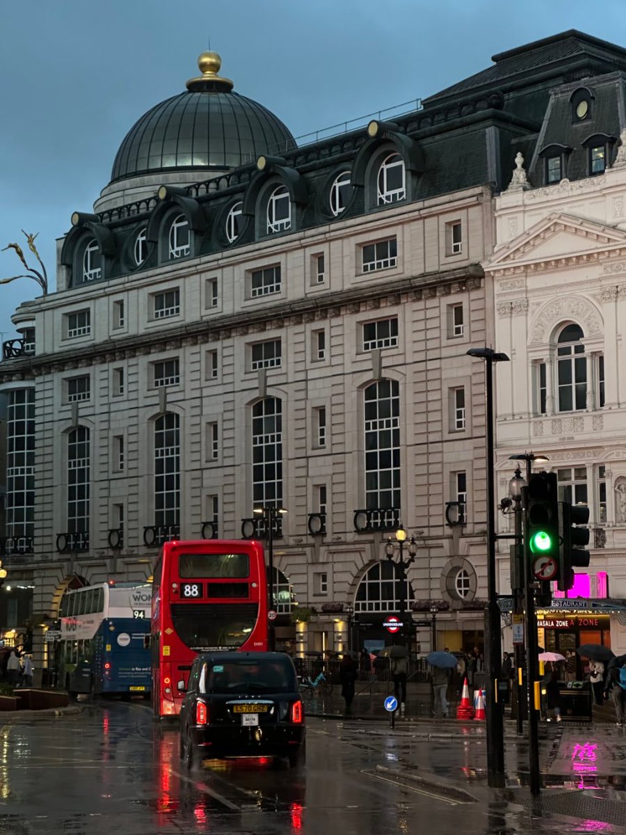 Chariya1a's tweet image. A rainy London street scene, showcasing historic architecture and bustling city life