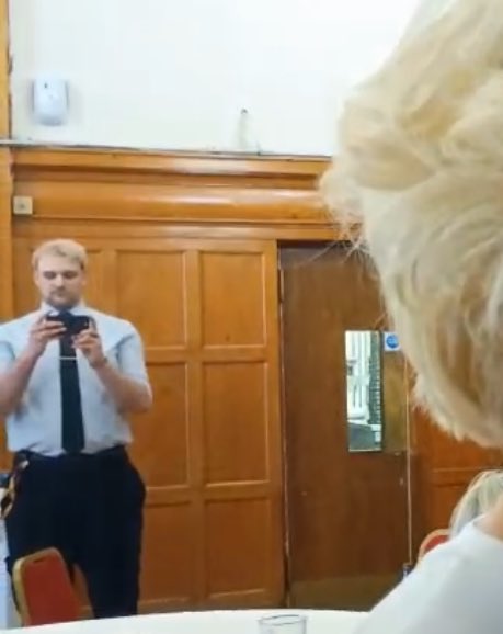 Another member of staff taking photos or recording within the private venue.