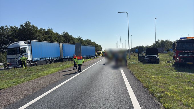 Voertuigen in de berm, hulpverleners op de weg. Vrachtwagen op de weg.