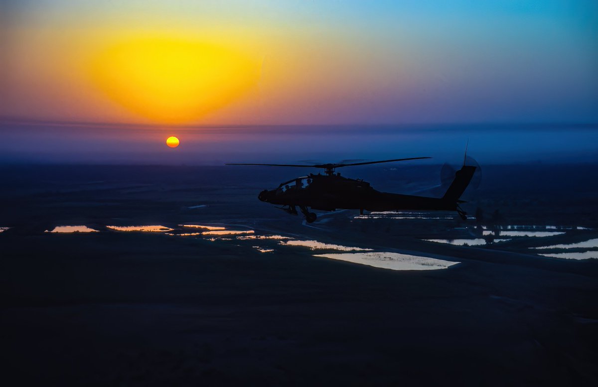 Sunrise north of Camp Taji, Iraq in 2005.  My photo of my wingman in his AH-64D at the end of our mission window.  This is a scanned 35mm color slide.