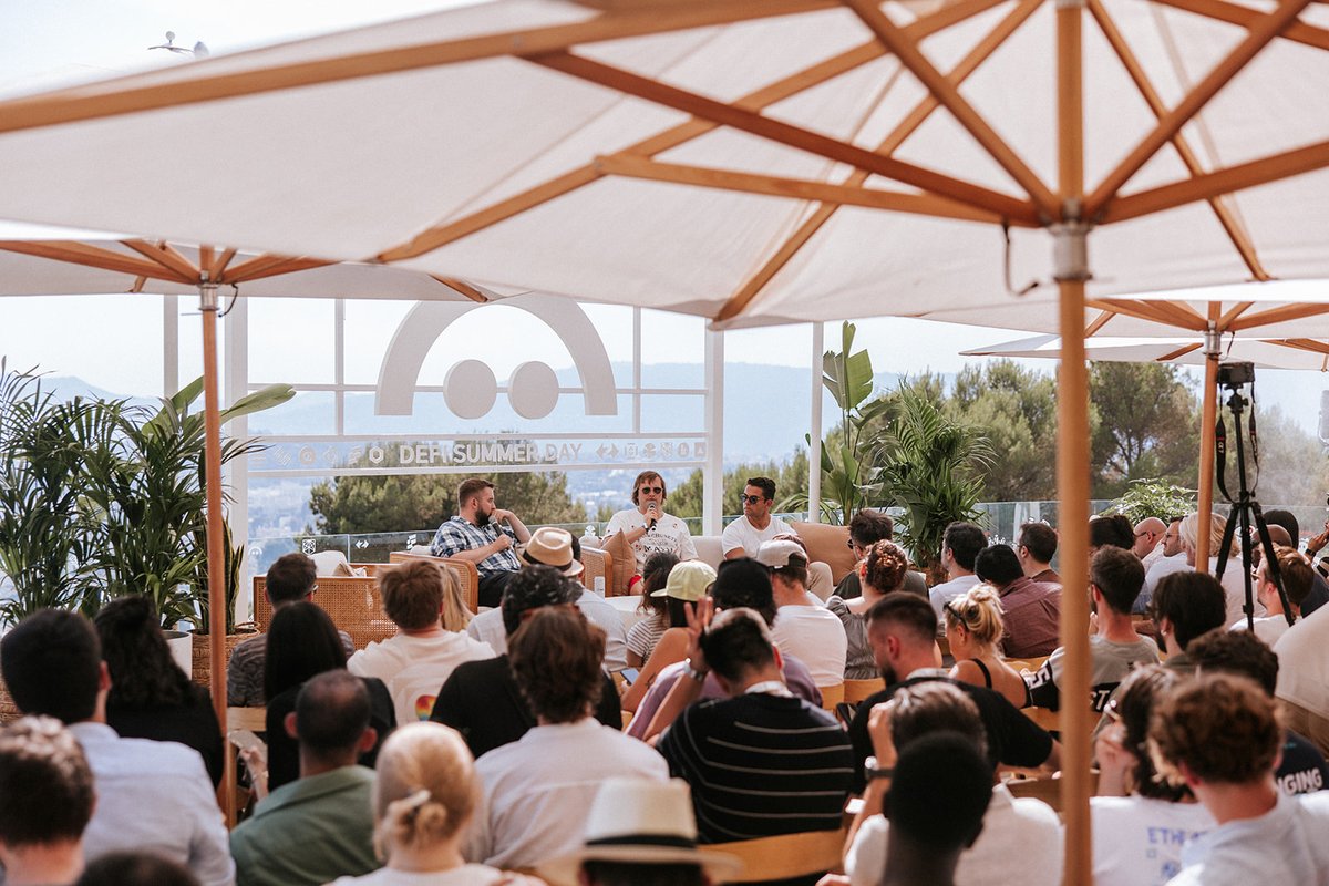 Crowd viewing a DeFi panel discussion outdoors
