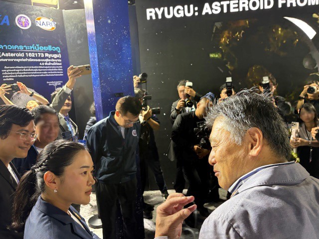 ISAS_JAXA's tweet image. 8月9日から17日までバンコクで開催中のMHESI Fairで、NARITとの協力により、日本以外で初となるアジアでのリュウグウサンプルを展示。スダワン・ワンスパキジコソル大臣らVIPや子供から大人までが鑑賞し、大臣は藤本所長の説明に熱心に耳を傾けていました。