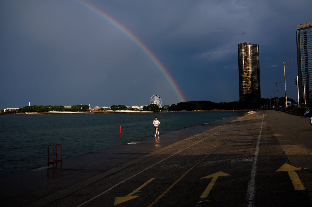 mandophotos's tweet photo. People walk near Ohio Street beach as a rainbow forms above Lake Michigan after a storm system moved through the area Tuesday in Chicago. https://t.co/33kQjX9nDY