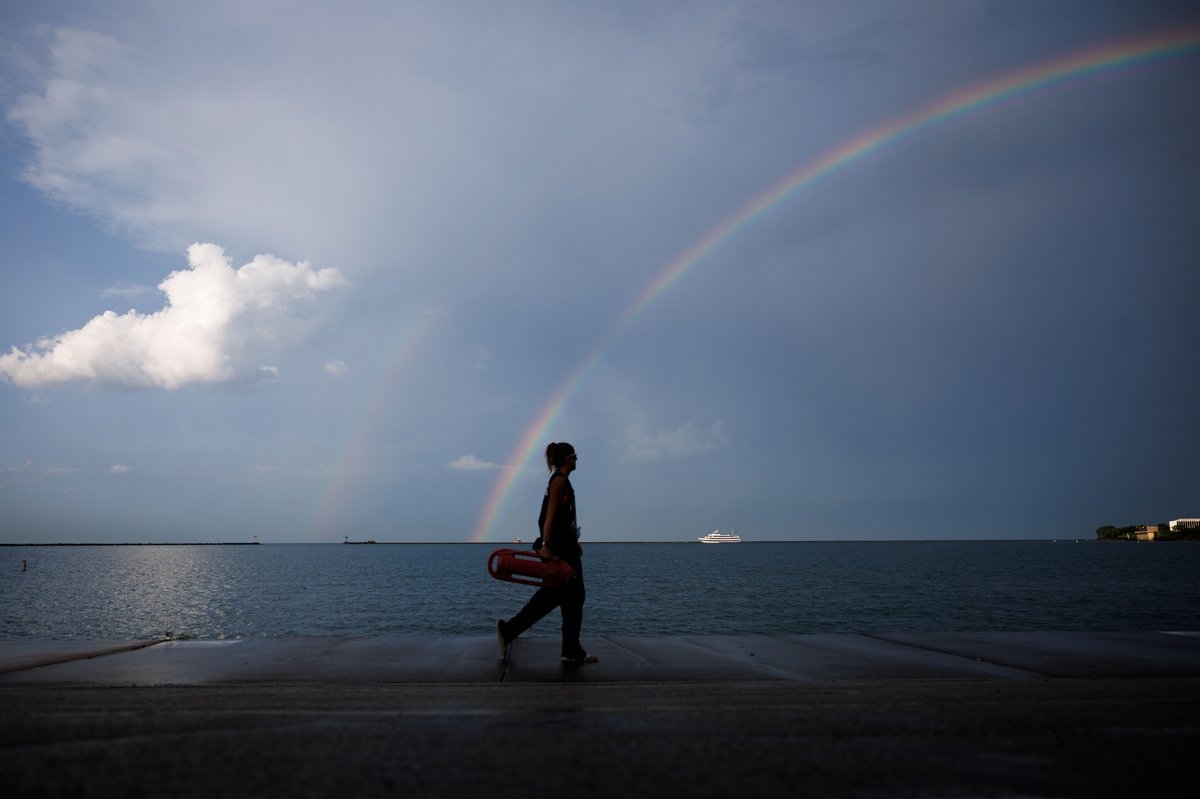 mandophotos's tweet photo. People walk near Ohio Street beach as a rainbow forms above Lake Michigan after a storm system moved through the area Tuesday in Chicago. https://t.co/33kQjX9nDY