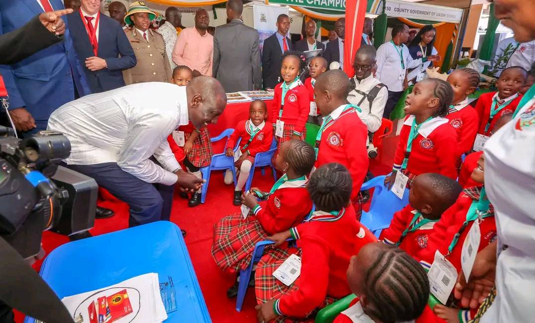 Bravebrandsmedi's tweet photo. President William Ruto interacts with ECDE pupils at the Kiambu County stand during the Devolution Conference 2025 in Homa Bay County. https://t.co/JwJXVYOfrO