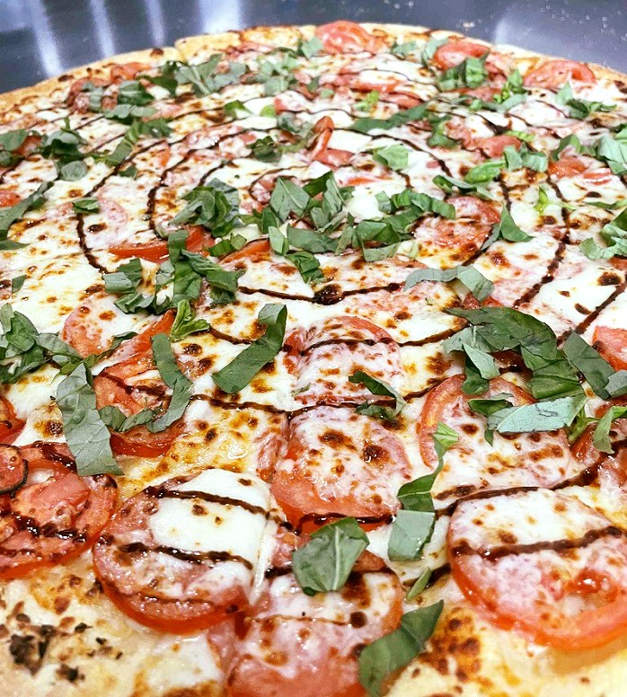 Thinking about veggin' out for lunch or dinner? Satisfy your taste buds with The Screamin' Tomato! Fresh mozzarella, mozzarella, vine-ripened tomatoes, pureed garlic and fresh basil (Balsamic glaze or our savory tomato sauce upon request).  Pic, Shep W.
#ExtremePizza #pizza #pov