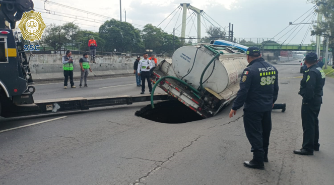 OVIALCDMX's tweet photo. Oficiales de #Tránsito de la #SSC realizan maniobras para retirar vehículo afectado por socavón en Calz. Gral. Ignacio Zaragoza antes de Anillo Periférico al Poniente.
#AlternativaVial Av. Texcoco.
#MovilidadCDMX https://t.co/8VL9qwOO7H