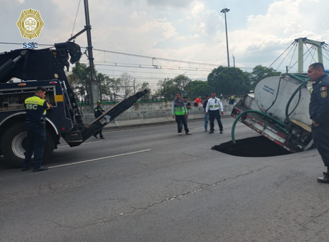 OVIALCDMX's tweet photo. Oficiales de #Tránsito de la #SSC realizan maniobras para retirar vehículo afectado por socavón en Calz. Gral. Ignacio Zaragoza antes de Anillo Periférico al Poniente.
#AlternativaVial Av. Texcoco.
#MovilidadCDMX https://t.co/8VL9qwOO7H