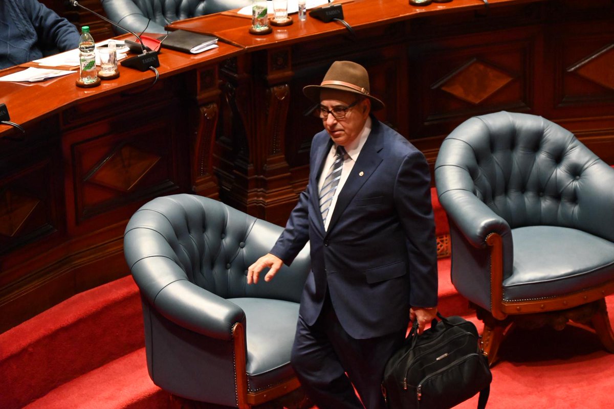 Dentro de la sala y con el sombrero, se me ocurre que lo debe tener atado , porque sino no lo entiendo