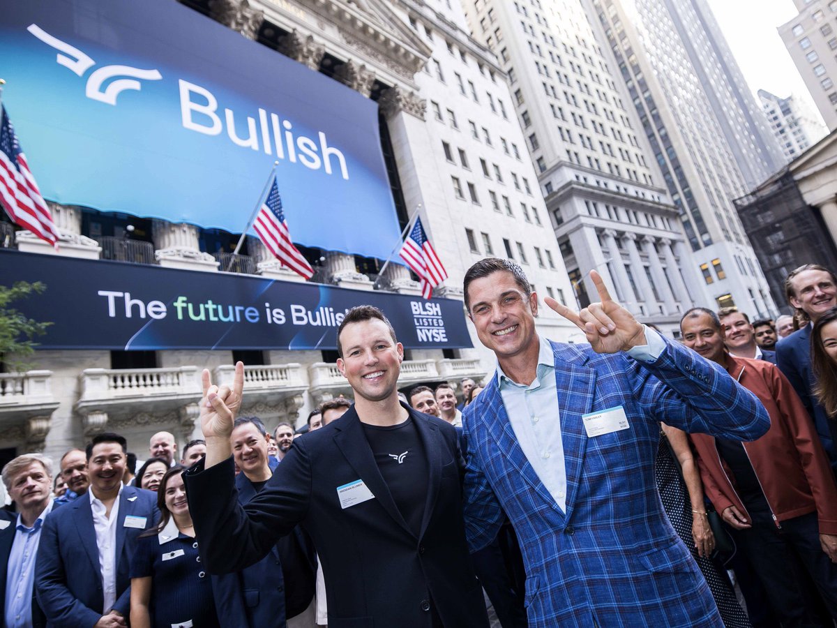 Bullish team celebrating IPO at NYSE with peace signs