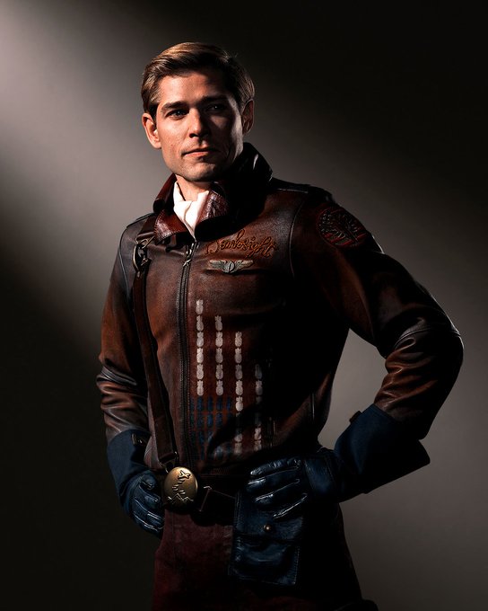 Mason Dye dressed as Bombsight for Vought Rising. He’s got a brown jacket that looks like pilot’s, with a white undershirt.