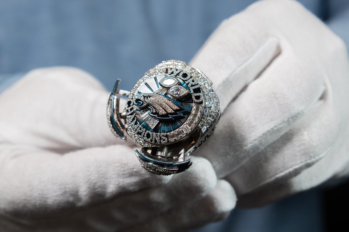 ProFootballHOF's tweet photo. It all starts with 145 diamonds, marking the record points scored in the postseason by the Eagles. Forty more form ‘WORLD CHAMPIONS,’ honoring their 40-point Super Bowl LIX win. Eighteen midnight-green sapphires represent 18 total wins. Hidden wings open to reveal a message: You can’t be great without the greatness of others. See the ring for yourself, now on display at the Hall of Fame!