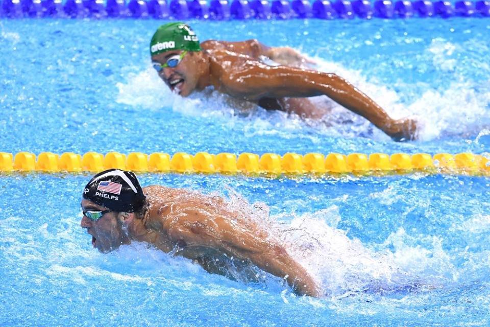 Michael Phelps swimming ahead in a race, symbolizing self-competition