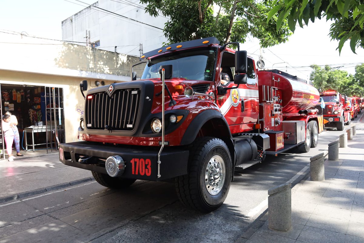 Desfile de Bomberos Voluntarios pasando frente a la Plaza Central.