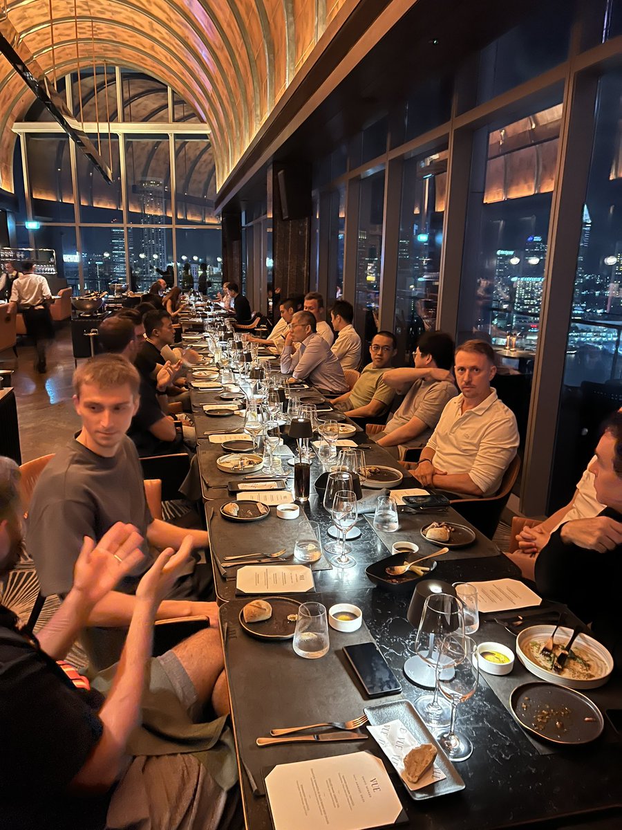 Crypto elites dining at the SHIFT Mastermind event in Singapore with city skyline views