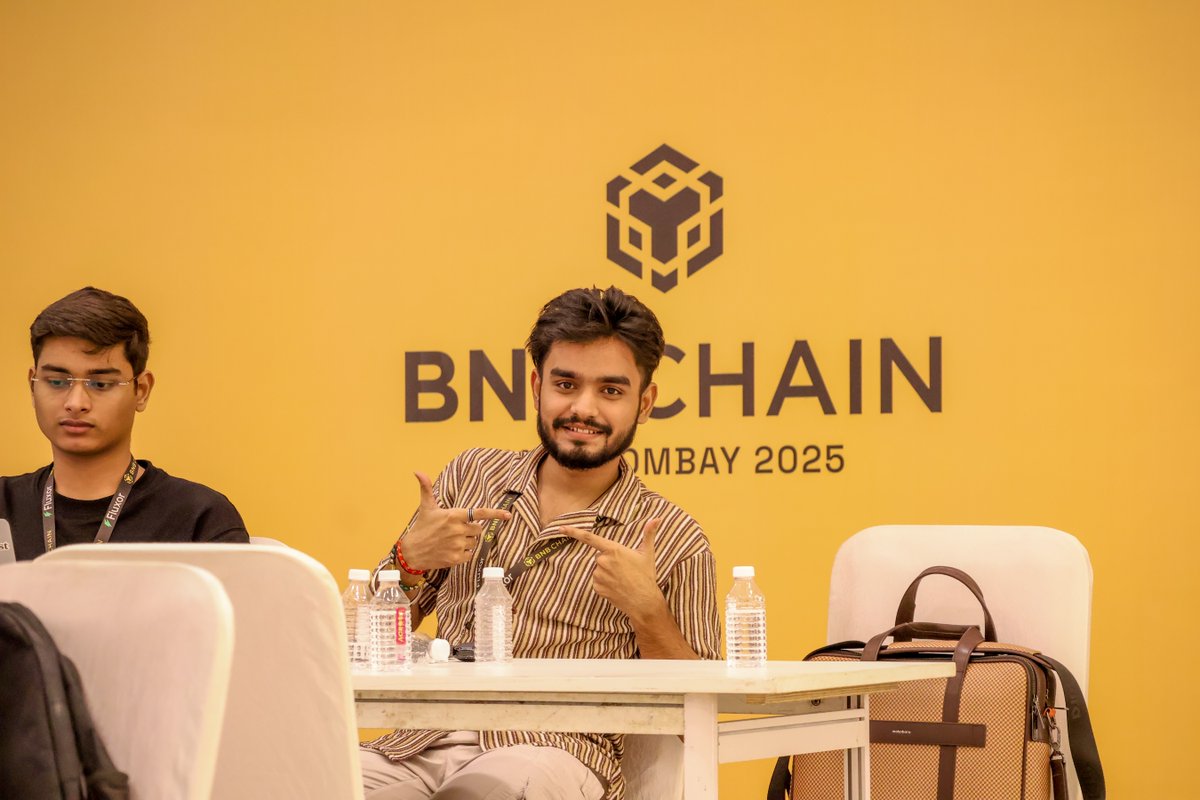 BNB Hack Bombay 배경 앞에서 포즈를 취하는 개발자들