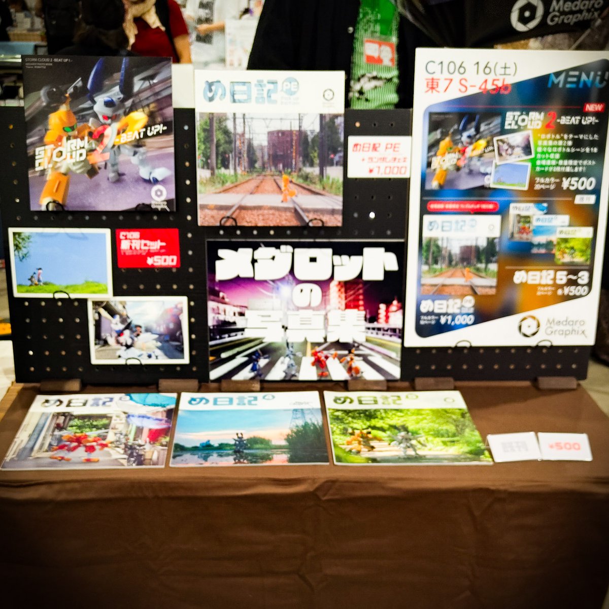 MedaroGraphix's tweet photo. 設営完了しました！
【東7 S45b】 MedaroGraphix
メダロット写真集出してます！
新刊はロボトルテーマ本第2弾『STORM CLOUD2 -BEAT UP!-』他、既刊の日常テーマである『め日記』シリーズを頒布します。

このポスターが目印！
#C106 https://t.co/F4MDtxVOaS
