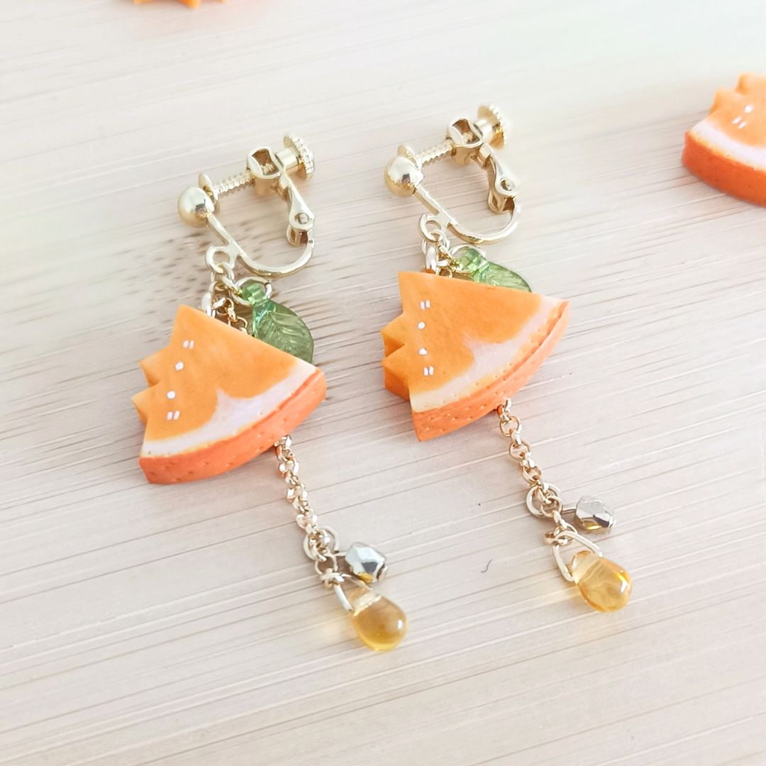 オレンジ猫のイヤリング。 じゅわっとおいしそうな果汁感と「よく見る