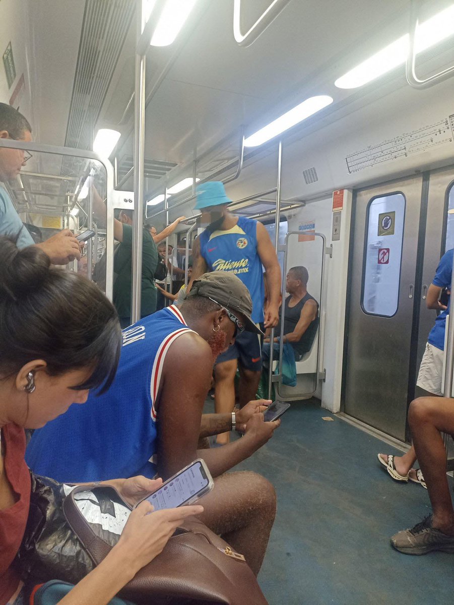 um cara com os acessórios do América no metrô kkkk