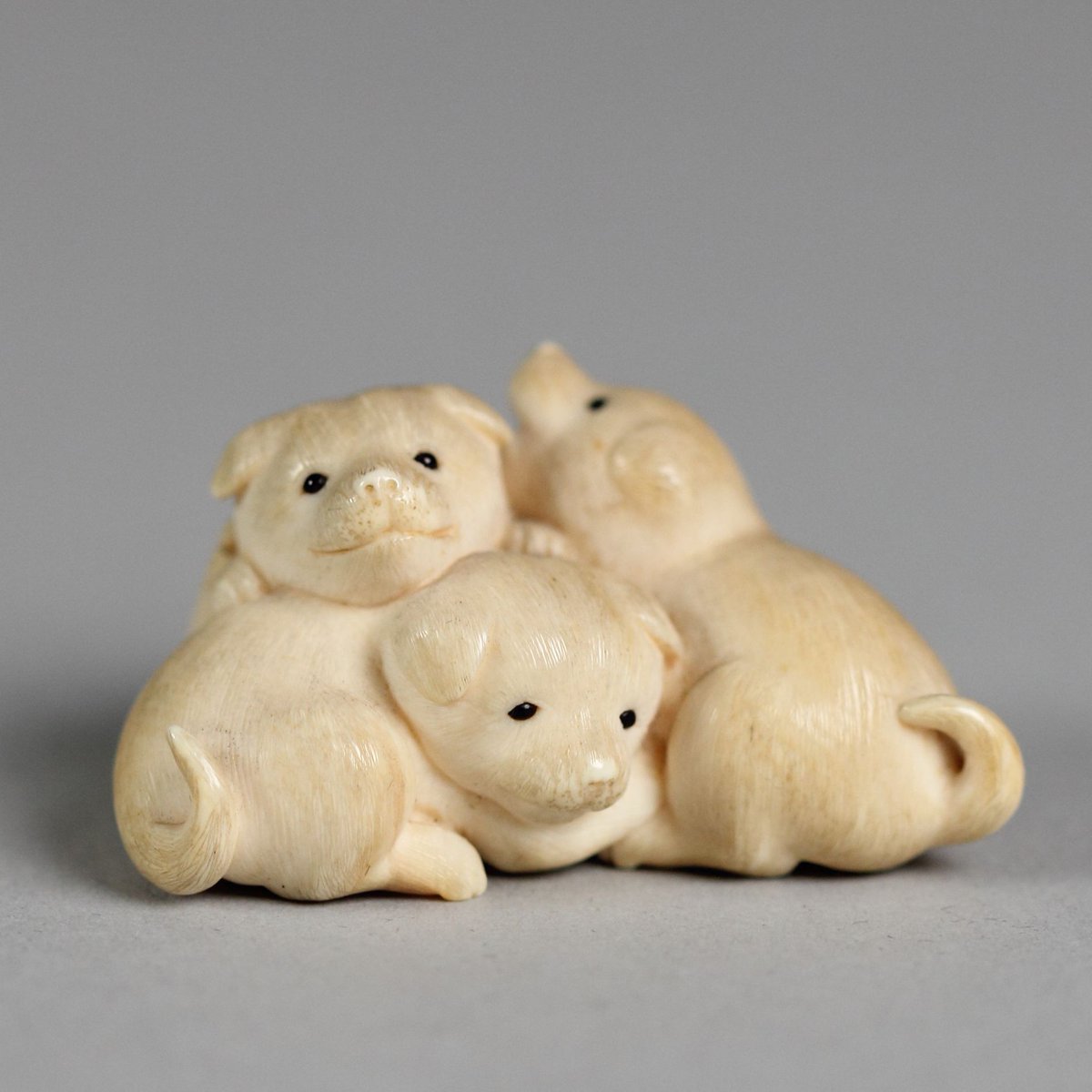 Netsuke of three puppies. Culture: Japanese (Edo period). Place of origin: Japan; 18th century AD. Medium: ivory. Collection: The Met.