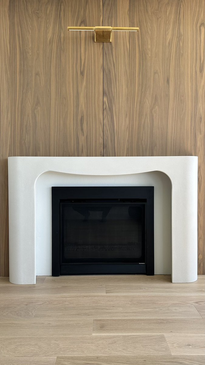 New custom fireplace surround installation. Soft curves, bold impact.