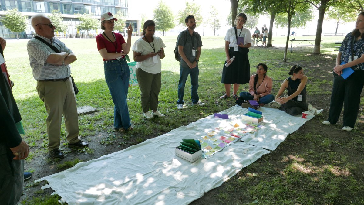 Sherbourne Common: Under shade in park, #FuturingWithNature led by #AlexisTennent, #JoanneRenaux, #ShaunAlfonso. Pairs of participants reflect on tree, crayon rubbings of signals of change. Exercise at #APF nexus #OCADU SFI guides  connections with nature. (Toronto) 20250816