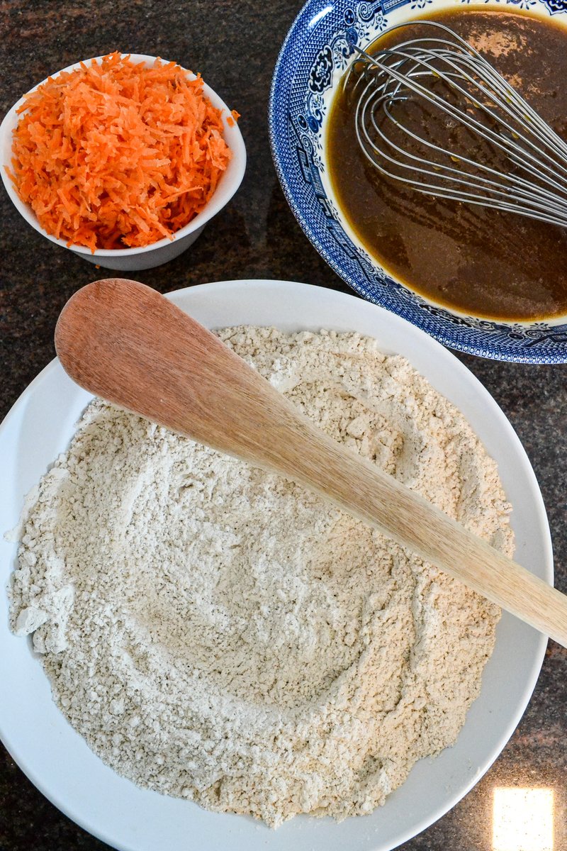 Whisk the oil, the eggs and the brown sugar together until silky soft -there should be no lumps. Now we have three sections that we need to bring together - the wet, the dry and the carrots

The carrots should be grated using the small holes of the grater so that they mix in well