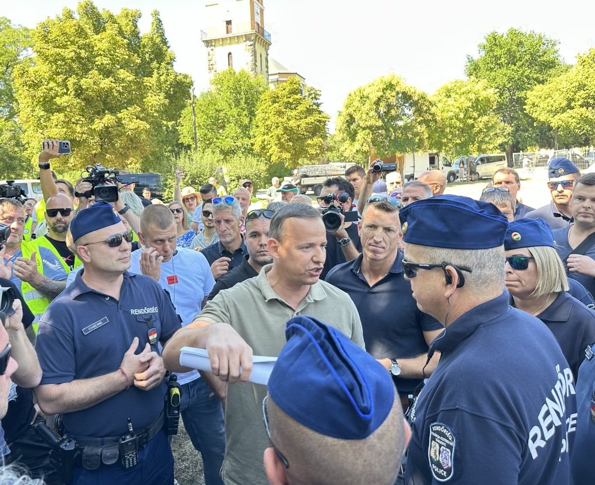 ToroczkaiLaszlo's tweet photo. Magyar Péter rendőröket küldött rám ma, amikor elmentem a dorogi utcafórumára. Tucatnyi biztonsági őrrel kellett hadakozni, hogy egyáltalán pár szót tudjak vele váltani. Milyen ember lenne belőle, ha hatalomhoz jutna, ha már most ilyen? 
Mivel a Meta felületein nem tudok reagálni a rólam és a Mi Hazánkról szóló rágalmazó Facebook-posztjaira, ezért mentem el személyesen, hogy így tudjak válaszolni a hazugságaira. Hátha csak nem ismeri a tényeket. Egy dossziét vittem neki, amit nagy nehezen sikerül átadnom, amely az összes parlamenti és önkormányzati szavazásainkat tartalmazta, bizonyítva, hogy mi senkinek sem vagyunk a "szatellitpártja". Mindig az elveink és a magyarok érdekei szerint szavazunk, és minden pártnál keményebben lépünk fel a korrupció ellen. 
Magyar Péter és Dávid Dóra nemcsak a Meta cenzúrája ellen nem szólalt fel eddig, de most élőben ugyanazt alkalmazta, mint Zuckerberg a virtuális térben. Értelmes kommunikáció helyett, karhatalmat küldött rám. Aztán, a több tucatnyi biztonsági ember háta mögül, a sebtében felállított színpad magasságából (fél órát csúszott a rendezvény, mert gyorsan egy kicsi színapdot dobtak össze neki, amikor meglátták, hogy ott várom a mikrofon mellett) másfél órán át tűrnöm kellett a provokációit, és újabb rágalmait, amelyet a magasból mondott rám  nézve. Szót nem kaptam, a mikrofonhoz nem engedtek, a mi mikrofonunkat a rendőrökkel elvetette. Így azt sem kérdezhettem meg, hogyan akarja Ruszin-Szendi Romulusszal felszámolni a korrupciót, amikor egy milliárd forintért építtetett magának luxus szolgálati lakást, és közpénzen esztétikai zsírleszívást végeztett magán. Ezt nem a Fidesz-propagandára alapozom, hanem megkérdeztem a mesterséges intelligenciát, hogy igaz-e a hír? Nem akartam elhinni, de igaz. A villát is megnézheti bárki személyesen is. Hogyan akarja a család- és társadalompolitikát Bódis Krisztára bízni, aki LMBTQ-mesekönyveket (Csipke Józsika stb.) írt a magyar gyerekeknek. 
Ha az én fórumomra jönne el egy pártelnök, akit visszatérően rágalmaznék, provokálnék, akkor én adnék neki 5 percet, hogy tisztázhassuk (mikrofonnal) a dolgokat, aztán kérném, hogy menjen el. Én is elmentem volna, ha ezt számomra biztosítja. Nem tette, így maradtam végig, tovább, mint Magyar Péter, miközben szidalmaztak és fenyegettek is a közönség soraiból. Szomorú, ha olyanok jelentkeznek hazánk irányítására, akik ilyen világot képzelnek el.