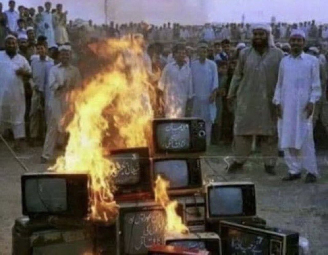 يحرقون التلفزيون لانه حرام بنظرهم، ويصورن الحدث بتلفونات الايفون والايباد لانه حلال...