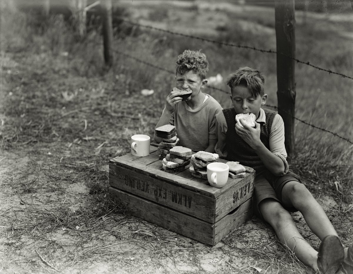 Piet André and Driekus Peters eat tasty sandwiches, Schoorl, Netherlands, 1949 - by Ben van Meerendonk (1913 - 2008), Dutch