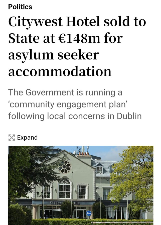 A building with a light-colored facade, large windows, and a central arched entrance. Trees and greenery are visible in front of the structure. Text overlay reads "Citywest Hotel sold to State at €148m for asylum seeker accommodation" and "The Government is running a \'community engagement plan\' following local concerns in Dublin".
