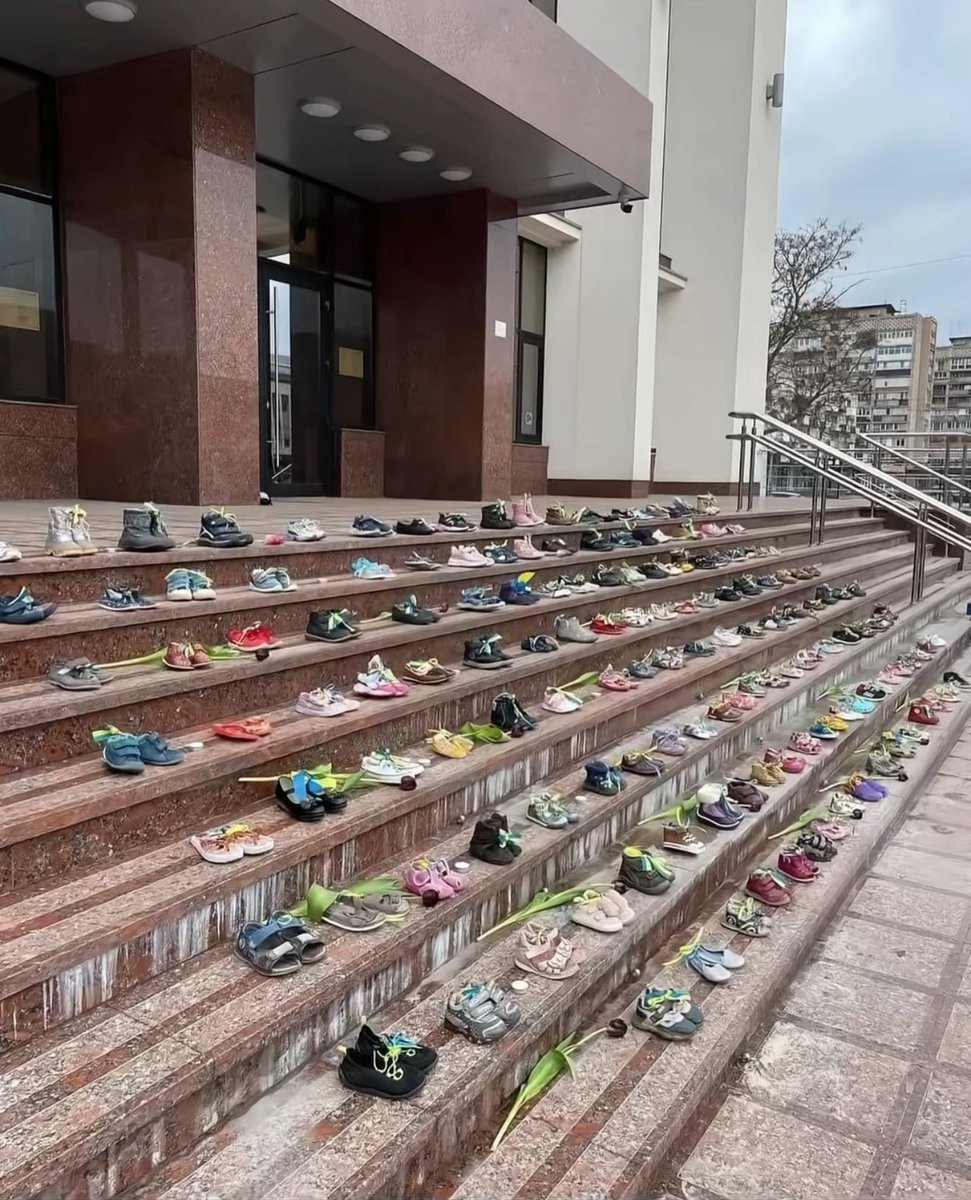 Children’s shoes placed at the school entrance in memory of the children killed by Russia, who will never walk through those doors again.