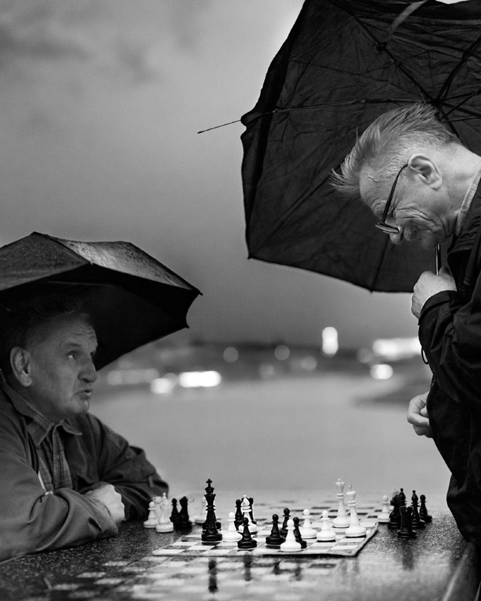 This photo is so wholesome that you might think the subjects were posing for it. But as the author explains, that was not the case:

"I was walking along the Vistula boulevard [in Krakow] on a cloudy day, taking photos. Suddenly, it began to rain, so I picked up my pace. Then I