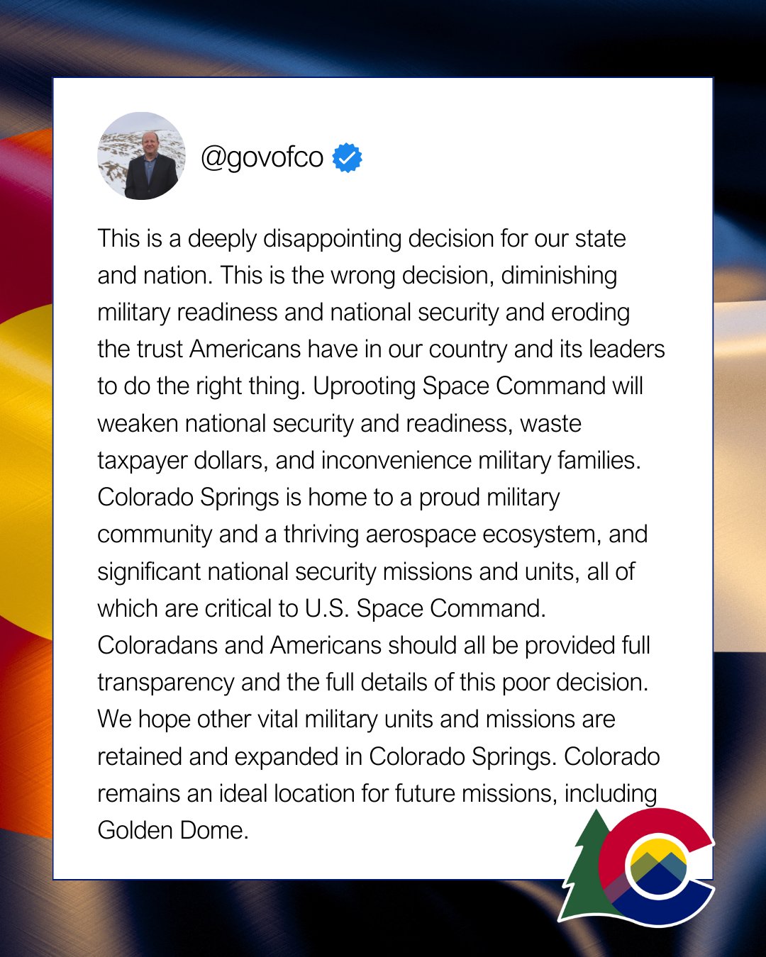 Background featuring Colorado state flag with a warm lighting and dark shadows and a white rectangle thinly bordered with black, featuring black text concerning Governor Polis recent response to President Trump’s decision to move the U.S. Space Command.