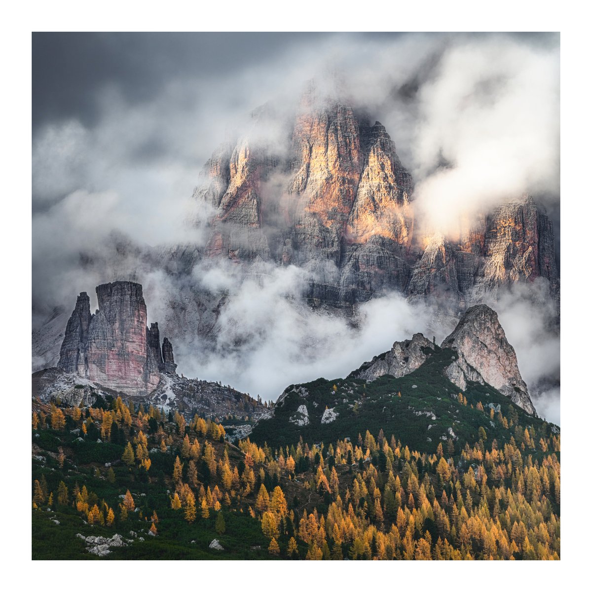 Golden larches beneath storm clouds, as the Dolomites briefly revealed themselves.